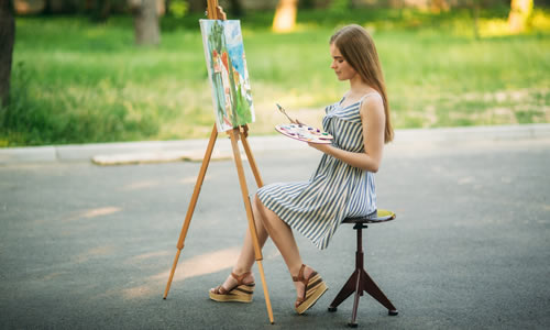 female artist painting in the middle of the road